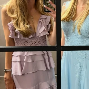 Balklänning - Säljer en ljuslila balklänning från true decendance med flera lager volanger och spetsdetaljer upptill. Klänningen har smala axelband och en djup v-ringning. Använd en gång i storlek xs. Klänning är uppsydd så att den passade mig som är 166. Nypris 1800