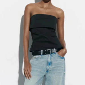 Svart topp  - Säljer en svart tubtopp med dragkedja bak.