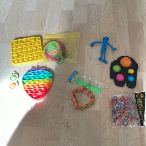 Fidget pop it-leksaker i olika former och färger - Säljer flera fidget pop it-leksaker, bland annat en svart pop it i form av en spelkontroll med färgglada bubblor och en regnbågsfärgad pop it i form av en jordgubbe. För det mesta helt förutom among us gubben som är lite trasig. Säljes i ett paket med allt för 40kr eller om man vill buda på något enskilt