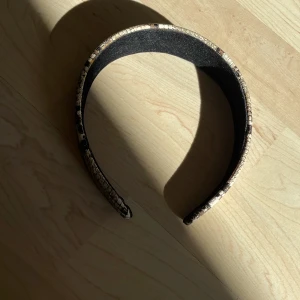 Brett diadem med ormmönster -  Diadem med bred form och ormmönstrad yta.