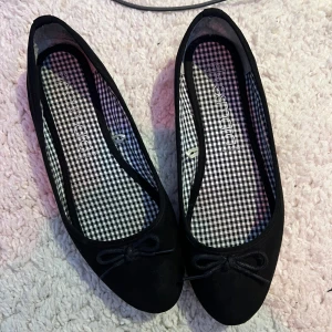 Svarta ballerinaskor med rosett - Klassiska svarta ballerinaskor från Atmosphere med söt rosettdetalj framtill. 