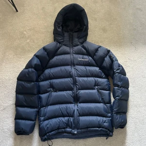 Mörkblå dunjacka Peak Performance - Säljer en mörkblå dunjacka från Peak Performance. Den är i bra skick då den använts fåtal gånger!