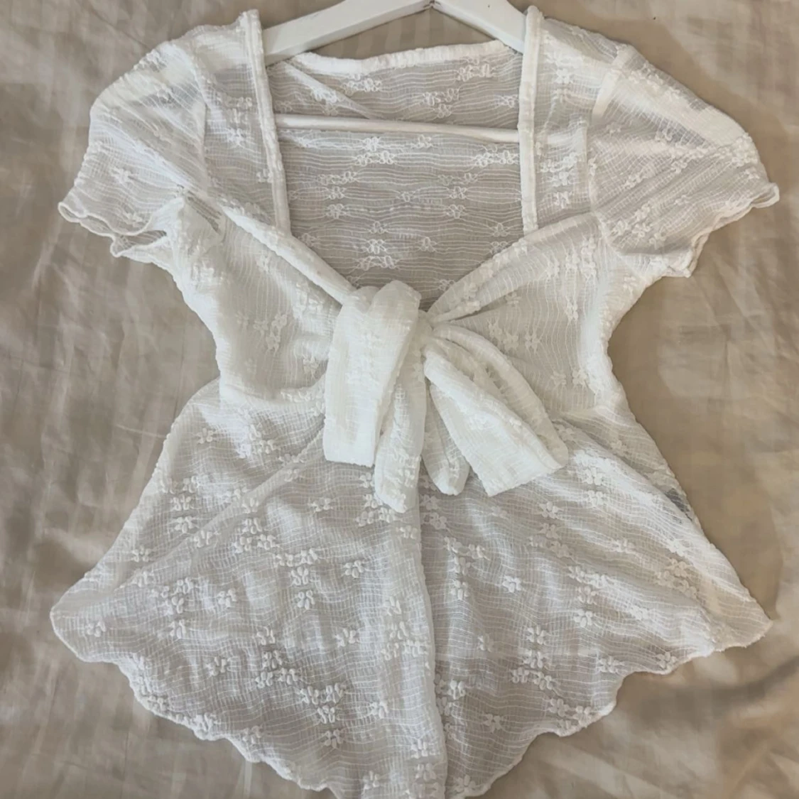 Vit blus med knyt och spetsdetaljer