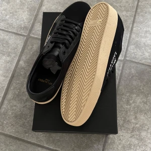 Svarta Saint Laurent sneakers - Snygga svarta skor från Saint Laurent – stilrena. Perfekta för att klä upp sig till fest, men funkar lika bra till en mer avslappnade, casual look. Bara att höra av er om ni vill ha fler bilder eller har några frågor! 