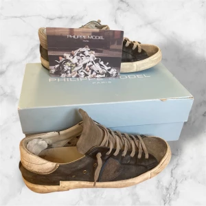 Philippe Model sneakers brun/grå, strl 41 - Snygga Philippe Model sneakers i brunt och grått med beige detaljer. Skorna har en cool vintage-look, rund tå och platt sula. Ovandelen är i mocka och skinn, med klassisk snörnin. Perfekta för dig som gillar Grisch och fransk design. Sulan har smått slitage men inget som märks! Riktigt feta inför hösten!