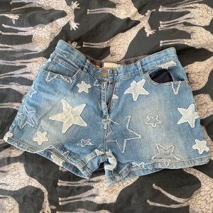 Stella McCartney jeansshorts med stjärnor 🌟  - Blå jeansshorts från Stella McCartney med stora och små ljusa stjärnor som är fastsydda över hela plagget.