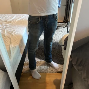nudie jeans  - Säljer ett par nudie jeans i storlek 29/32 men sitter som 30/32 också. Slitningar på knät.