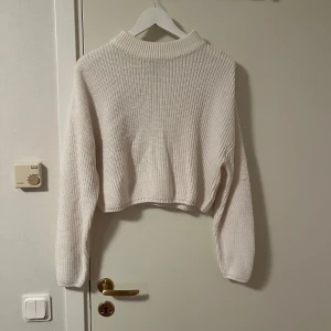 Vit stickad croppad tröja h&m - Säljer en vit stickad tröja från h&m i storlek M. Tröjan är croppad med hög krage och har långa ärmar. Perfekt för lager-på-lager och passar snyggt till både jeans och kjol. Enkel och stilren design som är lätt att matcha. Katt finns i hemmet 