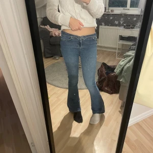 Blå bootcut jeans låg midja - Säljer ett par blå jeans med låg/mid midja och bootcut-ben. Jeansen har klassisk femficksdesign och är i ett mjukt denimtyg som sitter tajt upptill och släpper ut vid vaden. Storleken är: S, längd: 31 och de är från Bikbok. Jeansen är i fint skick och säljs endast då de är lite korta🥰