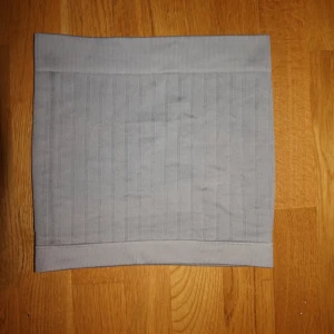 Ljusgrå tubtop - En stilren ljusgrå tajt tubtop. Den har diskreta vertikala ränder som ger en clean look och passar perfekt när du vill hålla dig varm och snygg. Enkel att matcha med olika outfits och smidig att dra över huvudet.