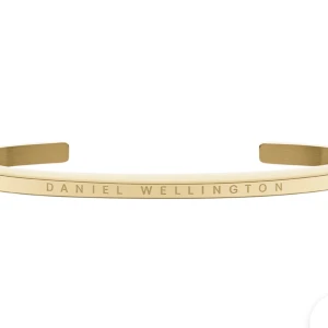 Guldfärgat armband Daniel Wellington - Stilrent och minimalistiskt guldfärgat armband från Daniel Wellington. Armbandet är stelt och öppet i modellen med märkets logga ingraverad framtill. Perfekt accessoar för en clean look och passar till allt.