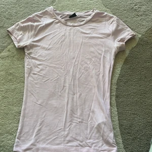 Ljusrosa t-shirt - En basic ljusrosa t-shirt från Gina Tricot i mjuk bomull. Modellen är klassisk med rund halsringning och korta ärmar. 