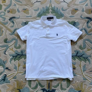 Vit pikétröja från Ralph Lauren - Klassisk vit pikétröja från Ralph Lauren med svart logga, storlek M