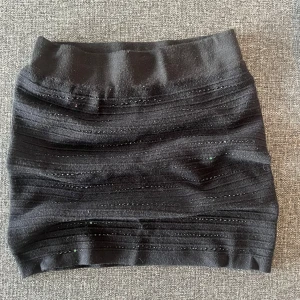 Svart tight kortkjol med glitterdetaljer - Säljer en svart tight kortkjol med horisontella ribbade ränder och små glittriga detaljer. 