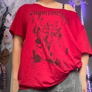 Röd oversized t-shirt med tryck⭐️ - Röd oversized t-shirt med svart tryck framtill som har gotisk text och ett stort kors. T-shirten har korta ärmar och en lös passform med bred halsringning som kan bäras offshoulder. Perfekt för dig som gillar alternativ stil.⭐️🪩