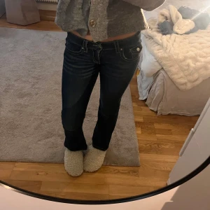  Gina Young jeans  - Snygga mörkblå jeans från Gina Tricot i bootcut-modell med låg midja. Snygga med kontrastsömmar, fram fickor och detaljer på bakfickorna. Perfekta för dig som gillar trendiga jeans och vill ha ett par byxor med lite utsvängda ben. ( finns ett litet hål vid bakfickan som man kan sy lätt och enklet)