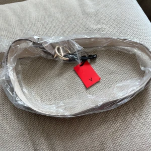 Valentino bälte beige - Fint valentinobälte i helt nytt skick. Färgen är beige brun och passar till mycket. Den är 110cm lång. Hör av dig vid frågor!