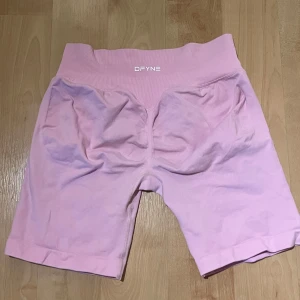 DFYNE Inpact shorts 6,5 - Säljer ett par ljusrosa träningsshorts från DFYNE i storlek medium. Observera att de är rätt små i storlek☺️ 