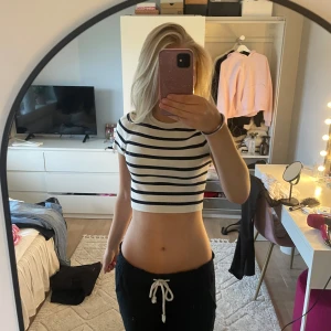 Randig croppad topp från Zara - Säljer en croppad topp från Zara med marinblå och vita ränder. T-shirten har korta ärmar, rund halsringning och sitter tight. Perfekt för dig som gillar en enkel men snygg stil. Superfin att matcha med höga jeans eller kjol!