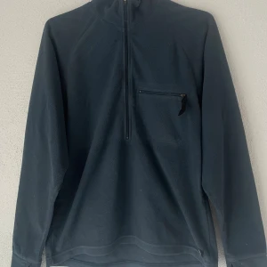 Nike ACG fleece half zip tröja blå - Mörkblå fleece-tröja från Nike ACG med half zip och hög krage. Tröjan har en bröstficka med dragkedja och är tillverkad i mjuk fleece som håller dig varm. Perfekt för kyliga dagar och outdoor vibes.