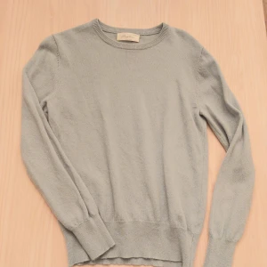 Ljusblågrå  kashmirtröja från Sayless - Supermjuk och stilren ljusblågrå kashmirtröja från Sayless. Klassisk rund halsringning och långa ärmar.. Tröjan har ribbade muddar.