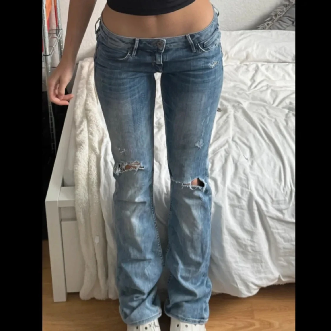 Blå bootcut jeans med slitningar