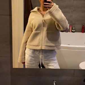 Beige HM teddyjacka  - Mysig beige teddyjacka med krage och två stora fickor framtill. Jackan har en rak och lite loose passform, långärmade ärmar och stängs med dragkedja. Perfekt för dig som gillar chill och comfy stil. Passar mig som vanligtvis har st S💞