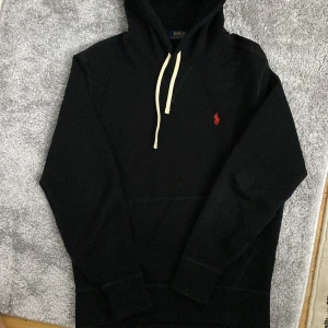 Svart hoodie  - Svart hoodie från Polo Ralph Lauren i storlek XS. Köpt helt ny för 2100kr och har används bra. Säljs för den börjar bli för liten för mig. Inga defekter alls. 