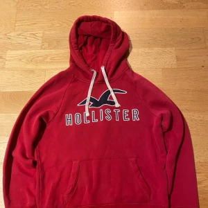 Holister hoodie  - En hoodie med perfekt passform och premiumkänsla. Inspirerad av klassisk Hollister-stil – avslappnad men stilren. Tillverkad i mjuk bomullsblandning med borstad insida för extra komfort. Ribbstickade muddar och justerbar huva med snörning ger en lyxig street-look. Passform: Regular-fit (sitter snyggt men inte för tight). Storlek: S Design: Enkel, ren logga på bröstet eller ton-i-ton broderi.