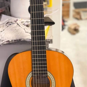 Messina 4/4 Size Germani  Classical Guitar - Messina 4/4 klassisk gitarr i fint skick. Vacker naturfinish och dekorativ rosett. Perfekt för nybörjare och avancerade spelare. Inga synliga repor eller skador på kroppen. Strängarna och greppbrädan ser välvårdade ut.
