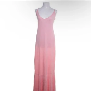 Ljusrosa maxi klänning från FAV - Ljusrosa långklänning/maxi klänning från FAV. Klänningen snören på ryggen så man kan spena åt. Klänningen är tillverkad i mjuk och är i stretchigt material
