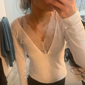 Uringad tröja - Vit v-ringad tröja med spets, aldrig använd så den är helt ny och inga skavanker förekommer! Hör av dig vid eventuella frågor!🤍