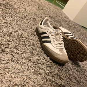 Adidas Sambas vit/svart 44 - Sköna sambas, sparsamt använda, kan inte gå fel med designen, äkta såklart köpta från zalando, säljs på grund av att dem är små, ställ gärna frågor om ni har funderingar 