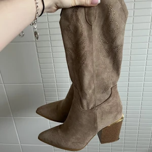 Beiga cowboy boots - Supersnygga cowboyboots med rhinestones i mockaimitation som jag köpte nya på vinted i somras. De har slitits ner lite på undersidan (se tredje bilden) men är i övrigt i mycket bra skick. Färgen visas bäst på sista bilden. Använd köp nu💗