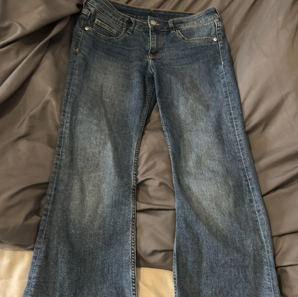 Blå bootcut jeans med slitna detaljer