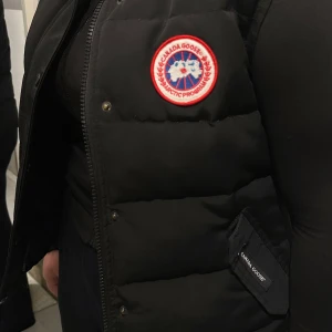 Canada goose väst  - Canada goose väst i stl XL passar även L. Sparsamt använd. Västan är i gott skick, Haft vid ridning under vinter tid. Inget jag använder idag.  Är ej sol skadad!   Köpt på Johnells för några år sedan. Tyvärr finns inget kvitto men äktenskaps etiketter finns.   Skulle rekommendera kemtvätt där av pris annars tillkommer avgift på 350kr för kemtvätt.   Nytt pris 4699kr   Pris kan diskuteras vid snabb affär!
