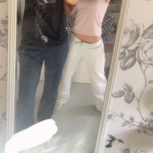 Gråa och svarta mjukisbyxor med snörning - Två par mjukisbyxor säljes! Ena paret är ljusgråa med bred resår och snörning i midjan, andra paret är svarta med samma sköna passform och snörning. Båda har loose fit och är perfekta för chill dagar. Tillverkade i mjukt bomullsmaterial.Båda kommer med!