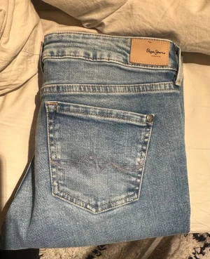 Ljusblå bootcut jeans från Pepe Jeans - Säljer dessa jeans då dom är förstora på mig i midjan/höfterna. Sitter helt okej runt benen men fortfarande lite stora. Skriv om ni vill ha mer info