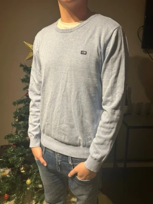 Ljusblå tröja från Lexington - Säljer en stilren ljusblå tröja från Lexington med rund halsringning och diskret logga på bröstet. Tröjan har ribbade muddar vid ärmslut och nederkant, och är tillverkad i mjukt material som passar perfekt till jeans. Skriv om du har frågor eller funderingar 