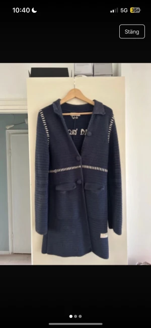 Mörkblå stickad kappa Odd Molly - Säljer en mörkblå stickad kappa från Odd Molly med snygga vita detaljer och stora knappar framtill. Jackan har två fickor, lång ärm och ett dekorativt bälte bak. Perfekt för dig som gillar unika och coola plagg med lite edge.