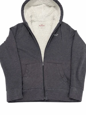 Fodrad hoodie från Hollister  - Säljer en lite schysstare hoodie ifrån hollister. Tröjan är i mycket bra skick, inga defekter som hål eller fläckar. Storlek S. Tröjan är mörkgrå