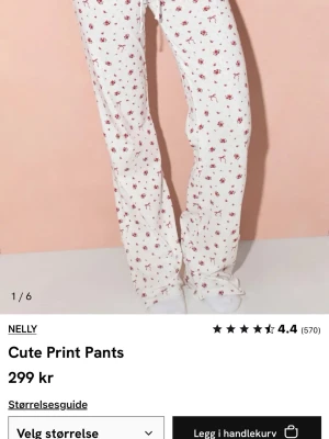 Vita blommiga mjukisbyxor från Nelly - Säljer ett par vita mjukisbyxor från Nelly med gulligt blommigt mönster i rött och rosa. Byxorna har rak passform och är tillverkade i mjukt bomullsmaterial, perfekta för chill dagar hemma. Supersöta och bekväma!