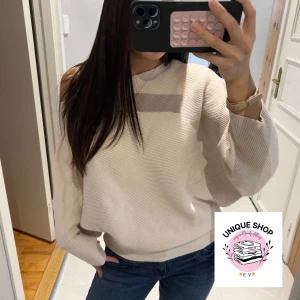 Ljusrosa  offshoulder stickad tröja - Säljer en ljusrosa stickad tröja med offshoulder-design och breda, långa ärmar. Tröjan har en loose passform och är ribbad i materialet, vilket ger en snygg struktur. Perfekt att matcha med jeans för en chill och trendig look.