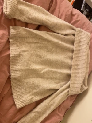 Beige stickad polotröja Gina Tricot - Mysig beige stickad polotröja från Gina Tricot i storlek 158/164. Tröjan har bred polokrage och ribbade muddar vid ärmslut och nederkant. Perfekt för kyliga dagar och enkel att matcha med jeans eller kjol.