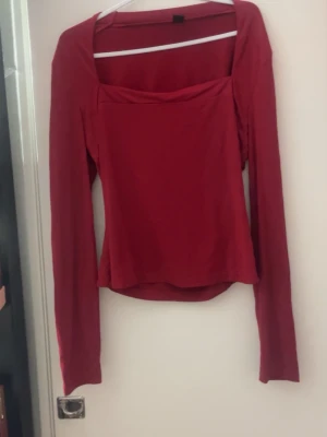 Röd långärmad topp från SHEIN - Säljer en röd långärmad topp från SHEIN i storlek M. Toppen har en snygg fyrkantig halsringning och är figurnära med enkel design. Perfekt att styla med jeans eller kjol för en cool look.