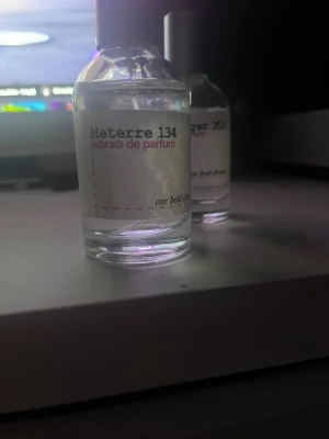 Meterre 134 extrait de parfum - Meterre 134 extrait de parfum med minimalistisk design. Perfekt för dig som vill sticka ut med en unik doft. Flaskans etikett har texten 'one bold choice'. Volym och ingredienser syns ej.