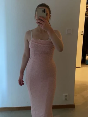 Ljusrosa glittrig långklänning - Säljer  en ljusrosa långklänning med glittrigt tyg och smala axelband. Klänningen har en figurnära passform och en snygg slits baktill. Perfekt för dig som vill sticka ut med en elegant look och älskar glitter. Klänningen är ifrån oh pooly men varumärket fans inte med i varumärket kategorin. Därför fick det bli Zara 