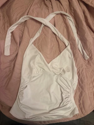 Vit  linnetopp - Säljer en vit linnetopp. Toppen har smala band som knyts runt nacken 