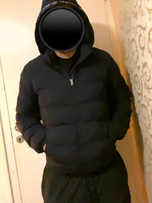 Mörkblå pufferjacka från GANT - Snygg och varm vadderad jacka från GANT. Jackan är i fint skick överlag och fungerar perfekt för höst och vinter. Obs: Det finns en liten reva/spricka på högra ärmen, men den är lätt att sy eller laga och påverkar inte funktionen.