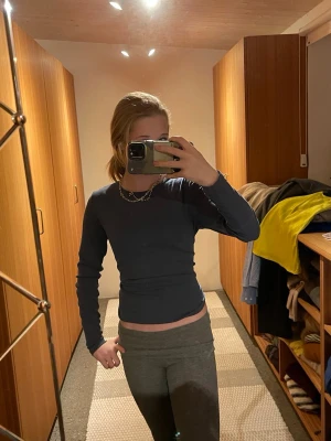 Mörkblå långärmad topp - Säljer en enkel och stilren mörkblå långärmad topp med tight passform. Toppen är croppad och har en rund halsringning. Perfekt att matcha med jeans eller kjol för en clean look. Har använt exakt 2 gånger 